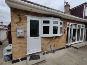 A uPVC bow window next to a uPVC back door.